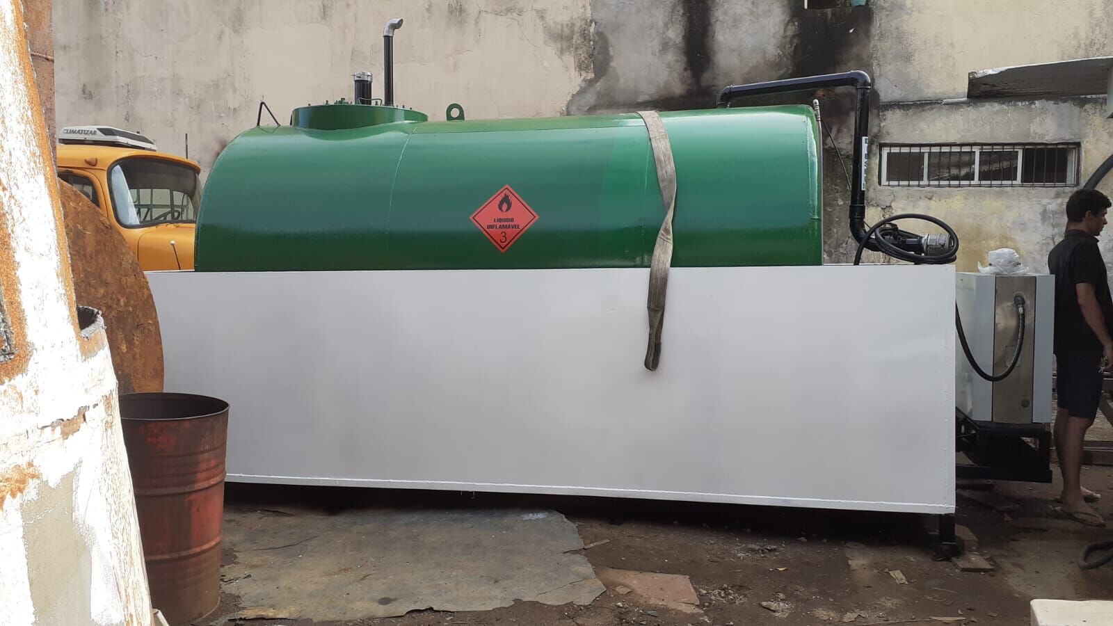Tanque aéreo verde com bacia de contenção dentro das normas ambientais